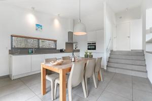 a kitchen and dining room with a wooden table and chairs at Beachfront VIP Villa - 4p - Luxe & Strand op 50m - Villa 59 in Ouddorp