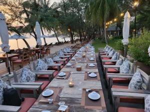 Ancarine Beach Resort في فو كووك: طابور طويل من الطاولات والكراسي على الشاطئ