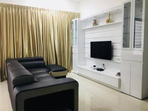 a living room with a couch and a television at 5BR 3Storey Cozy Gelugor Homestay 15pax in Gelugor