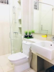 a white bathroom with a toilet and a sink at 5BR 3Storey Cozy Gelugor Homestay 15pax in Gelugor +14 photos