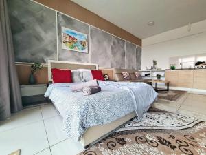a bedroom with a large bed and a kitchen at LG Studio @ EVO SOHO WIFI NETFLIX in Kampong Sungai Ramal Dalam