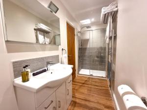 a bathroom with a sink and a shower at Min y Don Llandudno in Llandudno