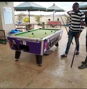 a man playing pool with a giant pool table at Comfy Studio Apartment with Pool in Nairobi