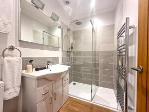 a bathroom with a sink and a shower at Min y Don Llandudno in Llandudno