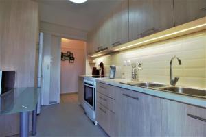 a large kitchen with a sink and a stove at Gazi apartment with Acropolis views in Athens