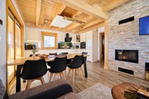 een keuken en een woonkamer met een tafel en een open haard bij Cottage Osojnik - Alpine escape with Wellness in Solčava