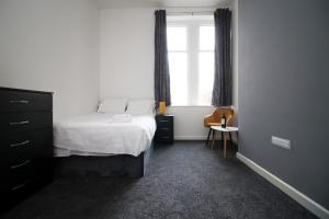 a bedroom with a bed and a window at Rugby Place by Tŷ SA in Newport