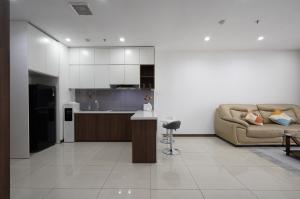 a living room with a couch and a kitchen at Aparment Hà Đô Centrosa in Ho Chi Minh City