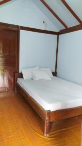 Bett in einem Zimmer mit Holzboden in der Unterkunft de Travelodge Homestay 