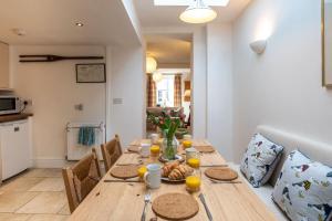 a dining room with a wooden table with food on it at 24 Rosemary Lane in Beaumaris
