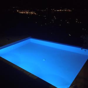 a blue light on a balcony at night at Hillside Villa over Lemonodasos in Galatas