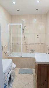 a bathroom with a shower and a toilet and a sink at Apartamenty Bałtyk Park in Ustka