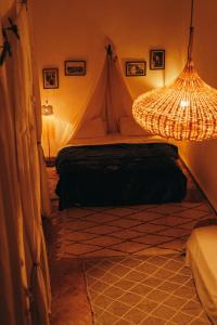 1 dormitorio con tienda y lámpara de araña en NOSADE Venue, en Marrakech