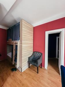 a bedroom with red walls and a chair next to a closet at Red Apple Hostel in Almaty