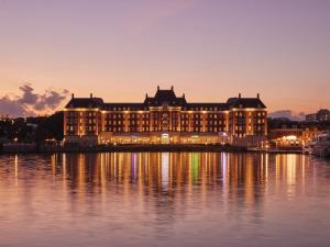 un gran edificio sobre el agua por la noche en Hotel Den Haag Huis Ten Bosch, en Sasebo