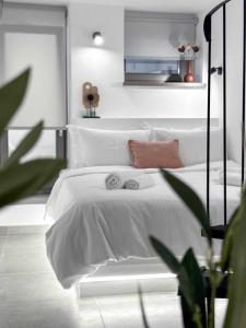 a bedroom with a white bed with towels on it at 1900 Apartments Ioannina in Ioannina