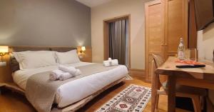 um quarto de hotel com uma cama com toalhas em Velar Hotel Boutique em Korçë