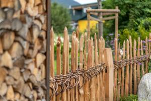una recinzione di legno accanto a un mucchio di tronchi di Hotel Bergland All Inclusive Top Quality a Seefeld in Tirol