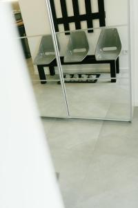 une salle de bains avec 2 chaises dans un miroir dans l'établissement Godiland Apartment, à Prague