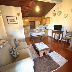 uma sala de estar com um sofá e uma mesa em 2 bedrooms villa with city view enclosed garden and wifi at Sorthela em Sortelha