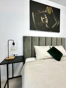 Chiajna的住宿－Elite Studio Militari Residence，一间卧室配有一张带桌子和一张照片的床