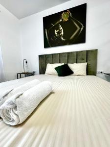 um quarto com uma grande cama branca e um cartaz na parede em Elite Studio Militari Residence em Chiajna