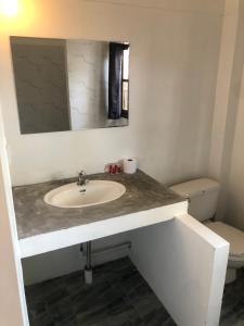 a bathroom with a sink and a toilet at Wild Wood x Hansa Beach Fitness Resort in Thongsala