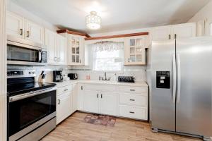 a kitchen with white cabinets and a stainless steel refrigerator at The Garnet Ranch Large Yard Near Jackson USC in Columbia