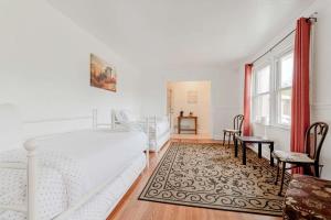 a white bedroom with a bed and a table at The Garnet Ranch Large Yard Near Jackson USC in Columbia