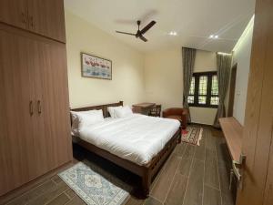 a bedroom with a bed and a ceiling fan at Coffee minas estate bungalow in Yercaud