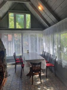 a screened in porch with a table and chairs at Casa Maia in Cîrţişoara