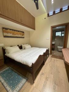 a bedroom with a bed and a bathroom with a tub at Coffee minas estate bungalow in Yercaud