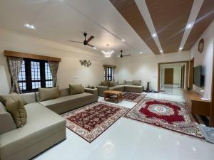 a living room with a couch and a tv at Coffee minas estate bungalow in Yercaud