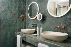 a bathroom with two sinks and two mirrors at FH55 Grand Hotel Palatino in Rome