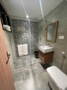 a bathroom with a shower and a toilet and a sink at Coffee minas estate bungalow in Yercaud