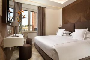 una camera d'albergo con letto e finestra di FH55 Grand Hotel Palatino a Roma