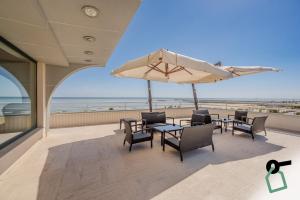 a patio with tables and chairs and an umbrella at HOTIDAY Hotel Giulianova in Giulianova
