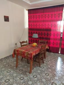 的住宿－Sunshine Guesthouse Bafuloto，用餐室配有桌椅和粉红色的墙壁