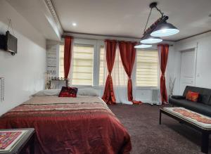 um quarto com uma cama, um sofá e janelas em The Empress Palace Hotel em Surrey