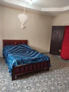 una camera con letto e piumone blu di Sunshine Guesthouse Bafuloto 