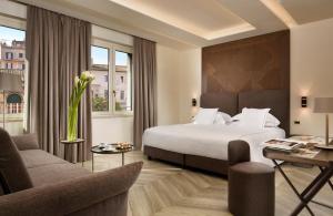 una camera d'albergo con letto, scrivania e sedie di FH55 Grand Hotel Palatino a Roma