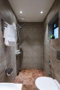 a bathroom with a shower with a toilet and a sink at Villas By Hangout in Lonavala