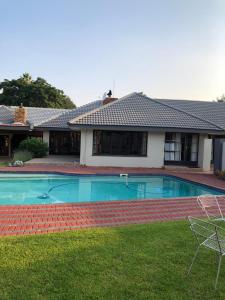 a swimming pool in the yard of a house at Serene Guesthouse in Middelburg