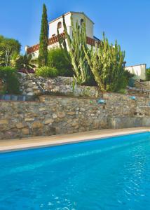 a house and a swimming pool in front of a house at Torre Costa Brava in Garrigás