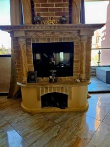 Elle comprend une cheminée en briques et une télévision. dans l'établissement Luxueux appartement à Sahara beach mohammedia, à Minaret de Mansuria
