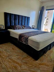 - un grand lit avec une tête de lit bleue dans une chambre dans l'établissement Luxueux appartement à Sahara beach mohammedia, à Minaret de Mansuria