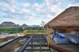 a pavilion with a thatched roof with a view of mountains at Beyond Skywalk Nangshi in Ban Met Nang Chi