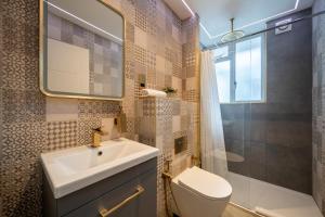 a bathroom with a sink and a toilet and a shower at Stay at Whitfield Street in London