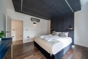 1 dormitorio con 1 cama grande y pared negra en Stay at Whitfield Street en Londres
