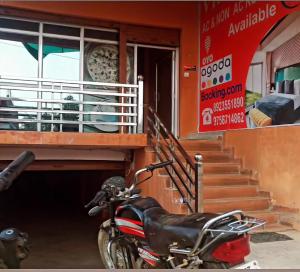 une moto garée devant un bâtiment dans l'établissement VR HOTEL, à Auraiya